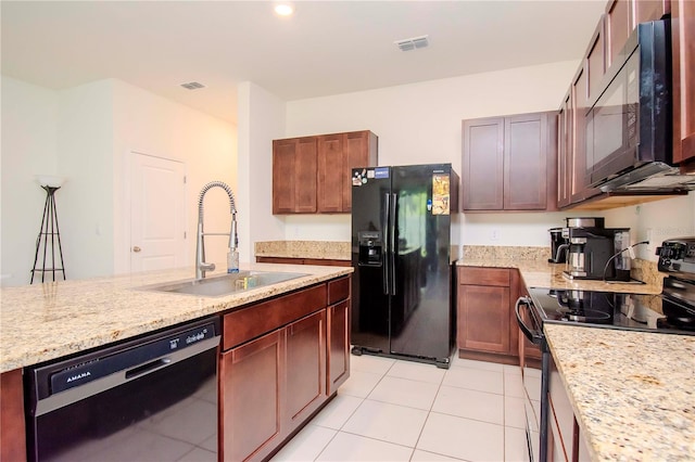 kitchen with sink, black appliances, light stone countertops, and light tile patterned flooring