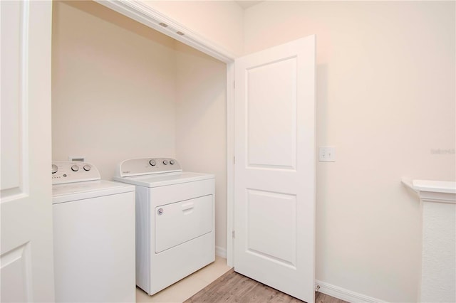 laundry room with light hardwood / wood-style flooring and washer and dryer