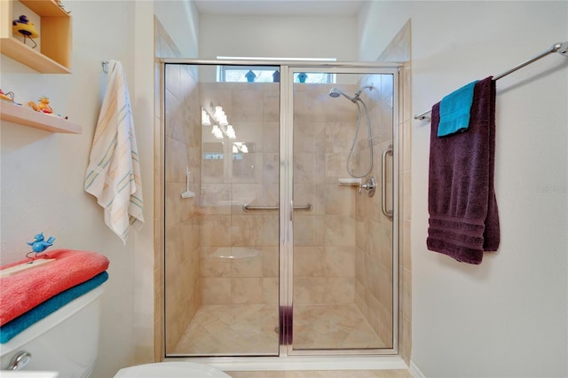 bathroom with toilet and a shower with door