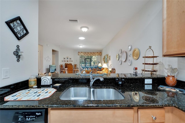 kitchen featuring black dishwasher, light brown cabinetry, sink, and dark stone counters