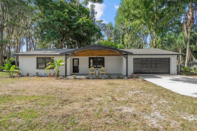 ranch-style home featuring a porch, a garage, and a front lawn