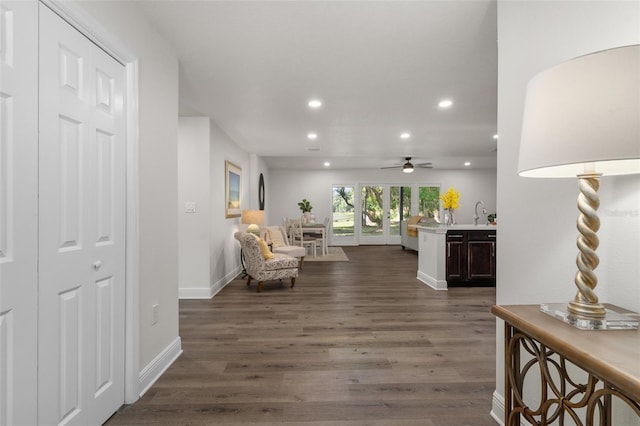 living room with ceiling fan, sink, and dark hardwood / wood-style flooring