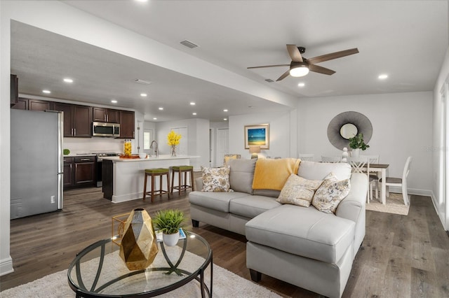 living room featuring ceiling fan and dark hardwood / wood-style floors