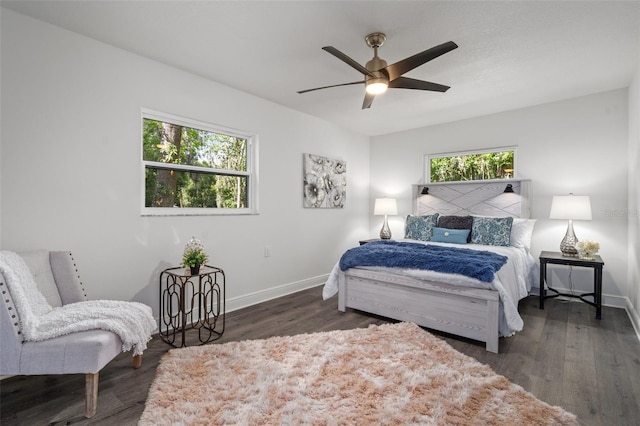 bedroom with ceiling fan, dark wood-type flooring, and multiple windows