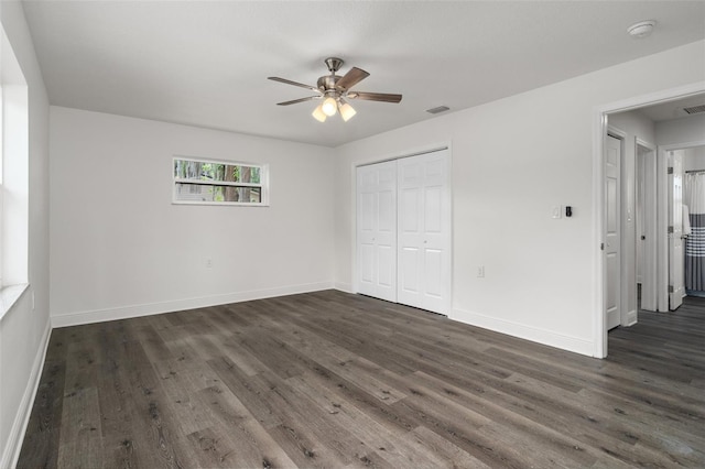 unfurnished bedroom with ceiling fan, a closet, and dark hardwood / wood-style flooring