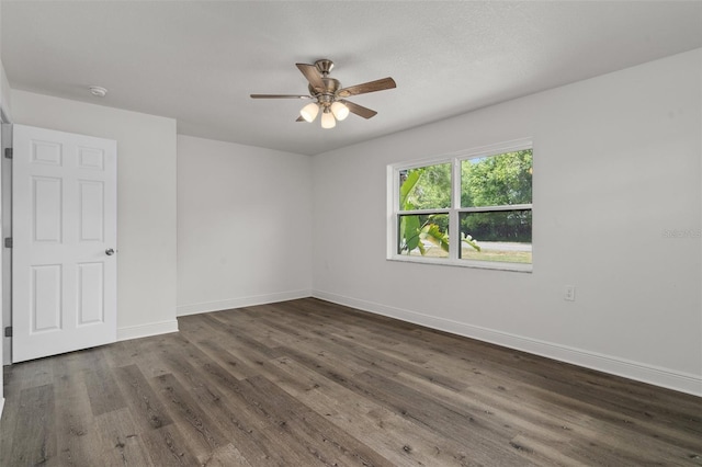 empty room with dark wood-type flooring and ceiling fan