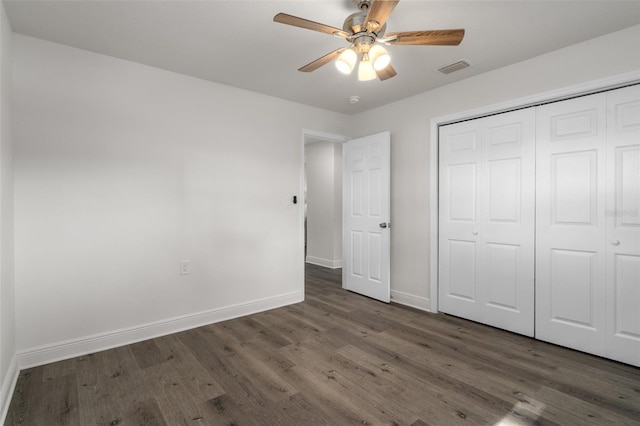 unfurnished bedroom featuring ceiling fan, dark hardwood / wood-style floors, and a closet