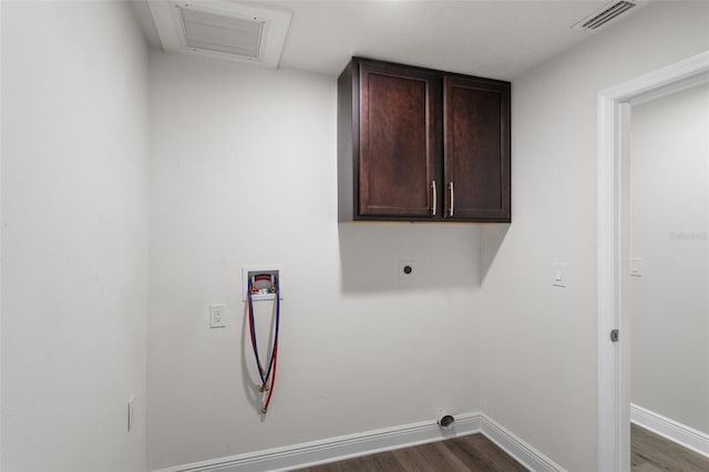 washroom featuring cabinets, electric dryer hookup, dark hardwood / wood-style flooring, and hookup for a washing machine