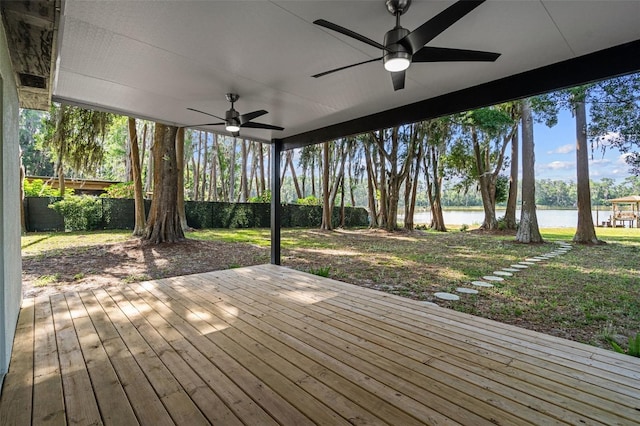 wooden deck with a water view and ceiling fan