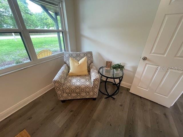 sitting room with plenty of natural light and dark hardwood / wood-style floors