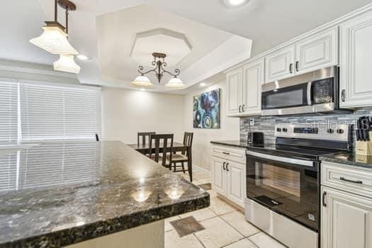 kitchen featuring appliances with stainless steel finishes, pendant lighting, and white cabinets