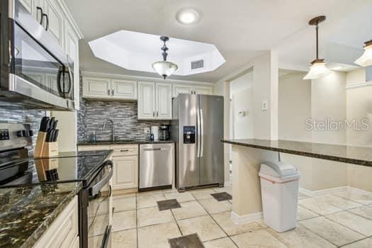 kitchen featuring pendant lighting, appliances with stainless steel finishes, sink, and tasteful backsplash