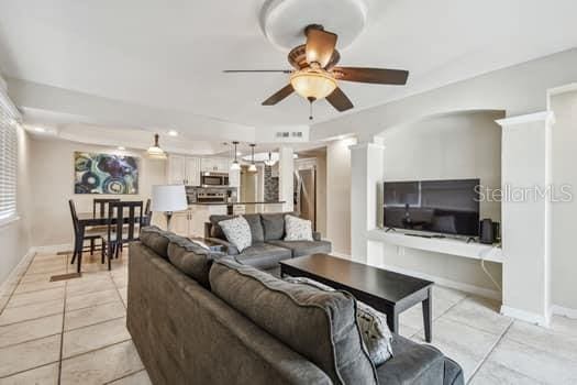 living room with light tile patterned floors and ceiling fan