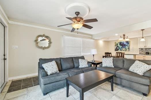 living room featuring ceiling fan and ornamental molding