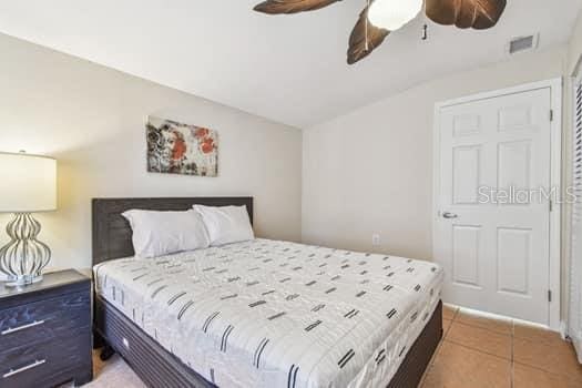 bedroom featuring dark tile patterned flooring, vaulted ceiling, and ceiling fan