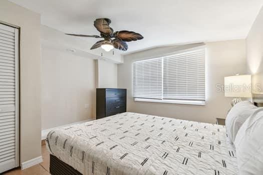 bedroom featuring ceiling fan, tile patterned flooring, and a closet