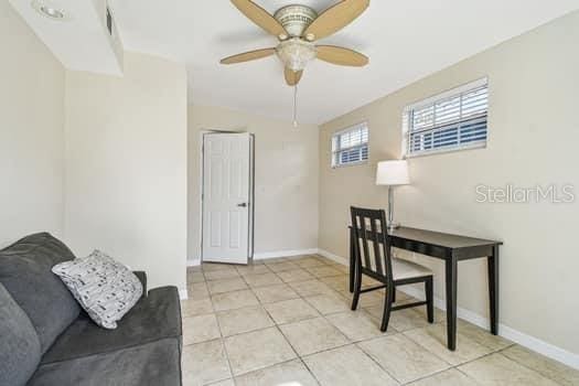 office with light tile patterned floors and ceiling fan