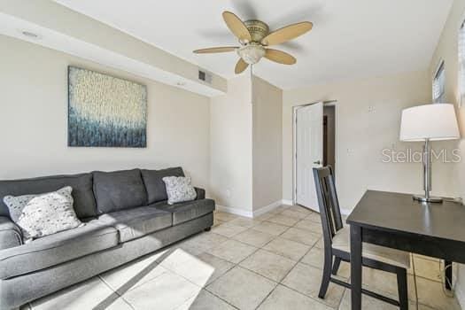 living room featuring light tile patterned flooring and ceiling fan