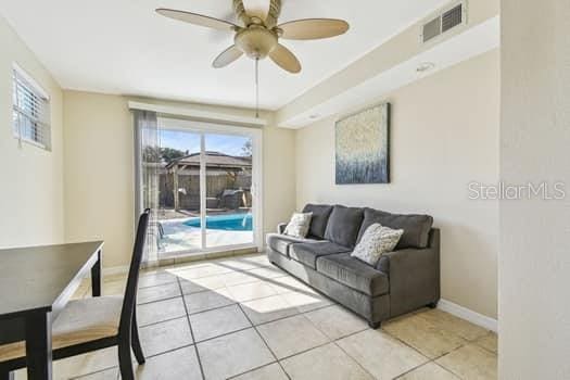 tiled living room featuring ceiling fan