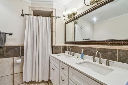 bathroom featuring crown molding, vanity, tile patterned flooring, and tile walls