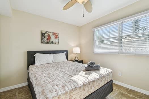 tiled bedroom with ceiling fan