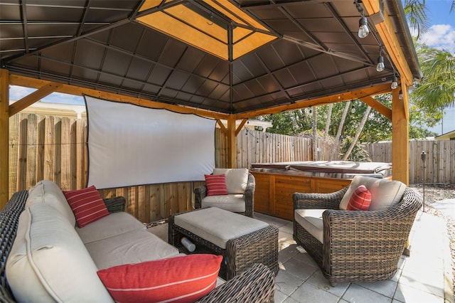 view of patio / terrace featuring an outdoor living space, a gazebo, and a hot tub