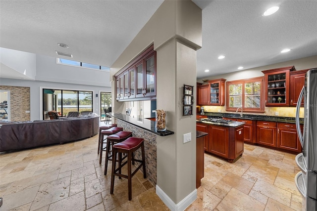 kitchen with plenty of natural light, a center island, stainless steel refrigerator, and light tile patterned floors