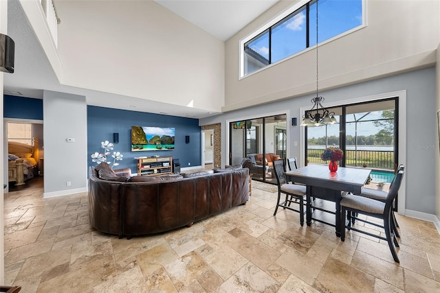 living room featuring a notable chandelier, light tile patterned floors, and a high ceiling