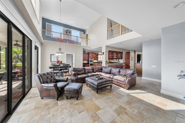 living room featuring an inviting chandelier, light tile patterned floors, and a high ceiling