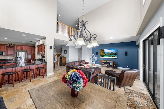 tiled dining space with an inviting chandelier and a high ceiling