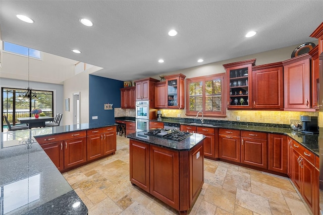 kitchen with decorative backsplash, stainless steel appliances, a center island, and light tile patterned floors