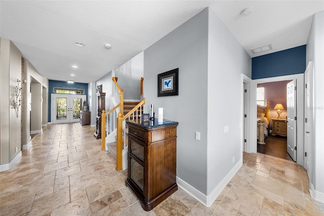 hall with french doors and light wood-type flooring