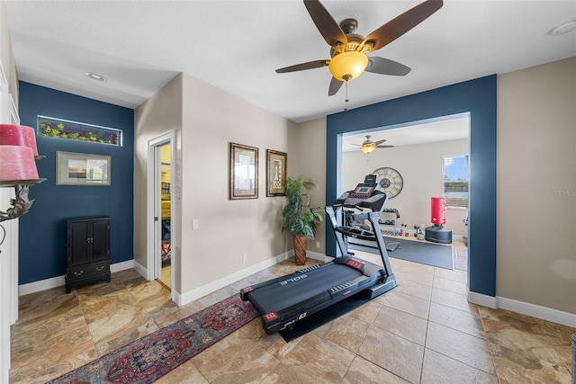 exercise room featuring tile patterned flooring and ceiling fan