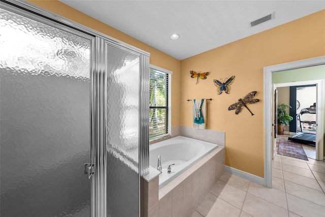 bathroom featuring tiled bath and tile patterned floors