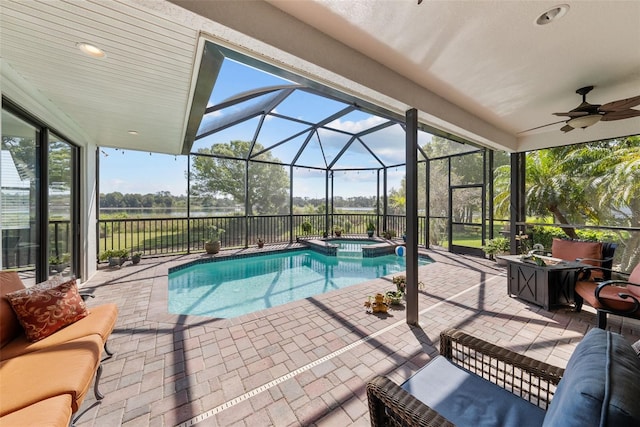 view of swimming pool featuring an in ground hot tub, ceiling fan, a patio area, and a lanai