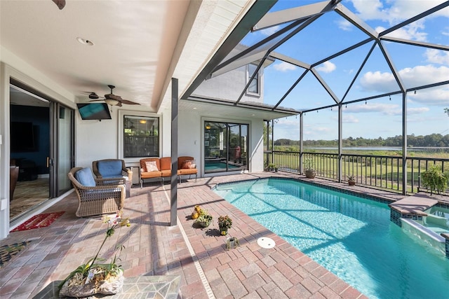 view of swimming pool with a patio, glass enclosure, and ceiling fan