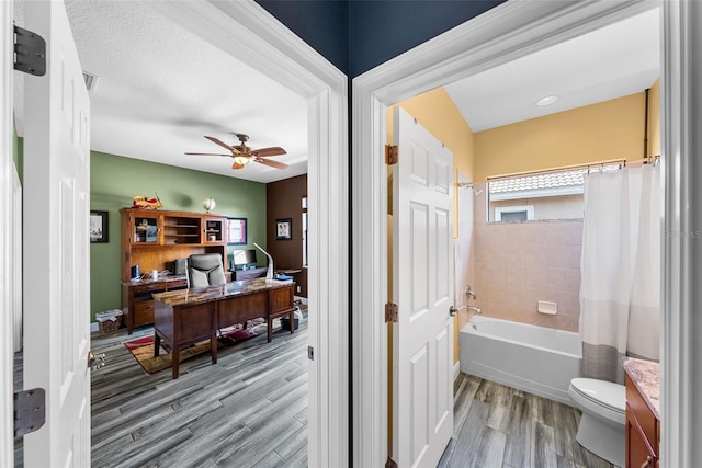 full bathroom with shower / bath combo, toilet, vanity, ceiling fan, and wood-type flooring