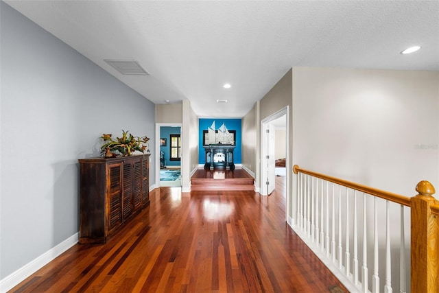 hallway with dark hardwood / wood-style flooring and a textured ceiling