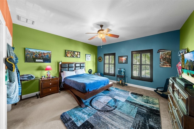 carpeted bedroom featuring a textured ceiling and ceiling fan