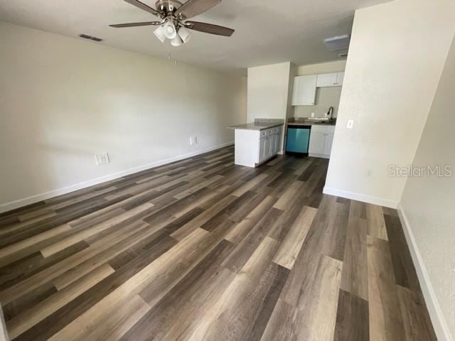 empty room with ceiling fan and dark hardwood / wood-style floors