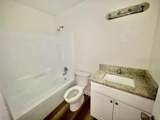 full bathroom with shower / bath combination, vanity, hardwood / wood-style flooring, and toilet