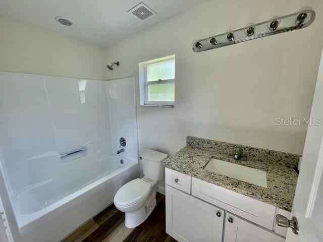 full bathroom with bathtub / shower combination, hardwood / wood-style flooring, vanity, and toilet