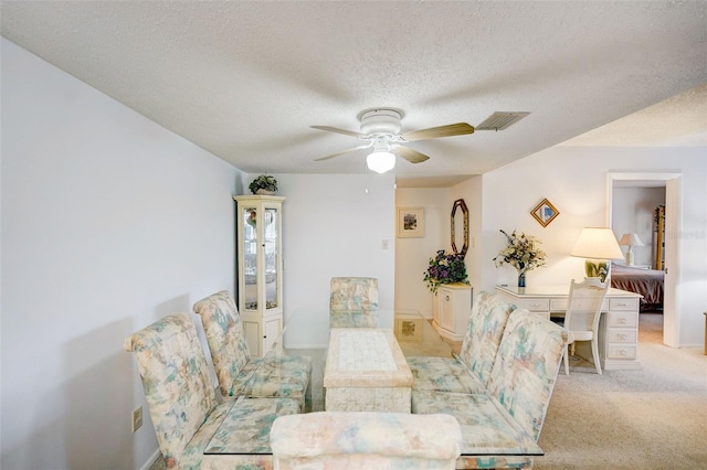 living room with light colored carpet, a textured ceiling, and ceiling fan