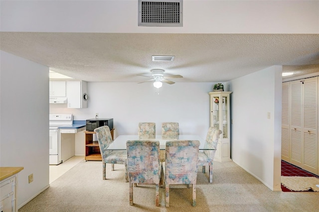 dining area with light colored carpet, ceiling fan, and a textured ceiling