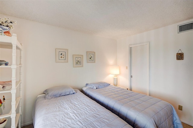 carpeted bedroom with a textured ceiling