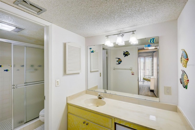 bathroom featuring toilet, tile flooring, a textured ceiling, an enclosed shower, and vanity