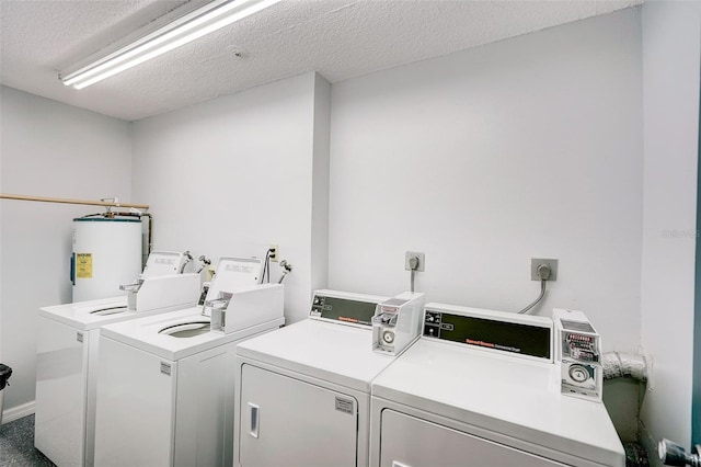 washroom featuring a textured ceiling, washer and dryer, electric dryer hookup, and electric water heater