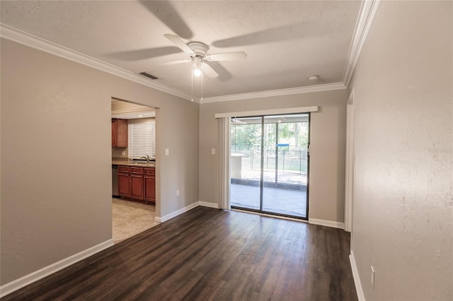 spare room featuring wood-type flooring, ceiling fan, crown molding, and sink