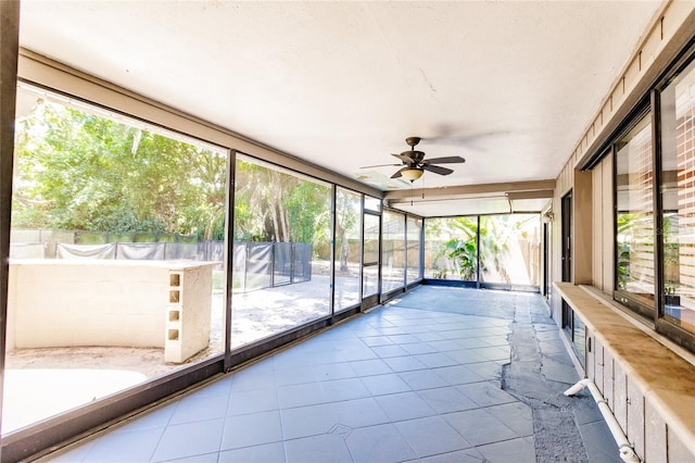 unfurnished sunroom with ceiling fan