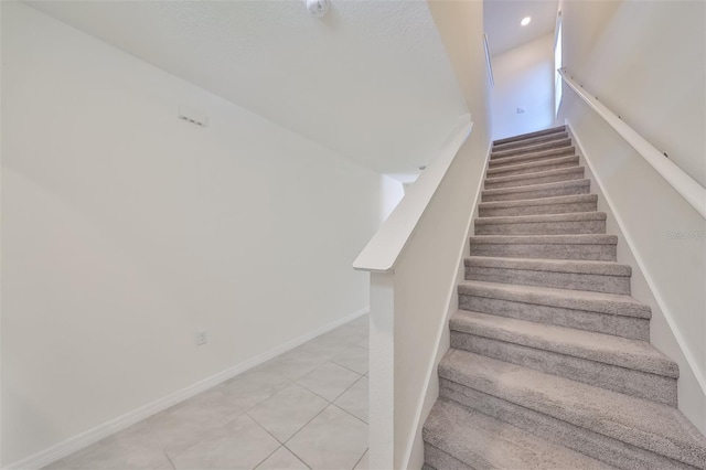 staircase with light tile patterned floors